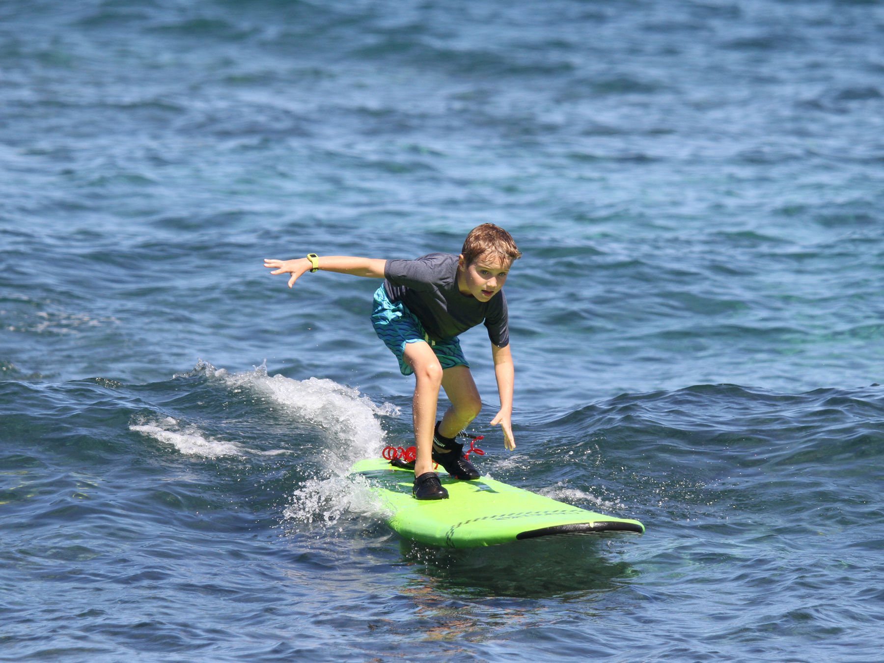 Young surfer student riding a wave