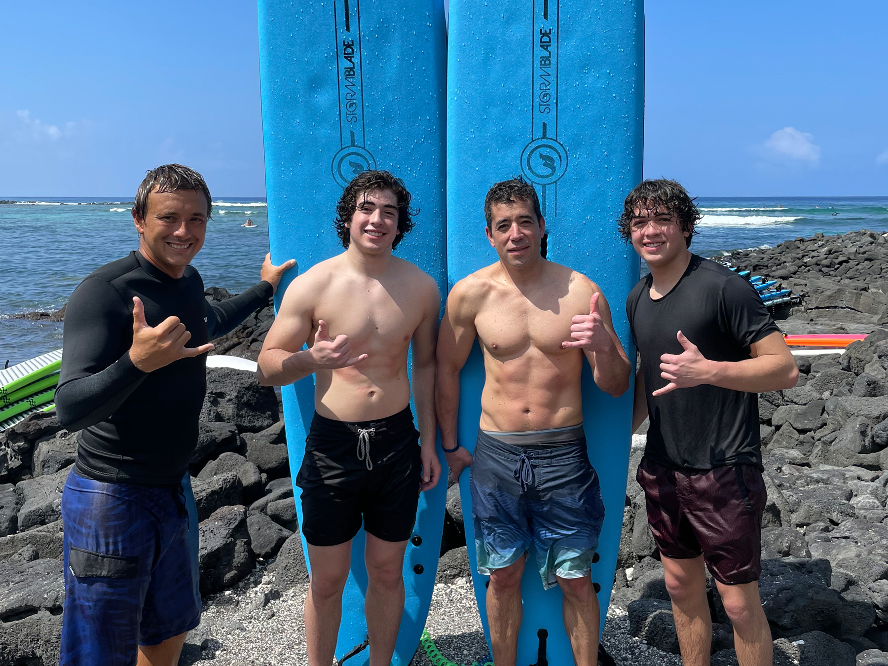 Surf instructor Kaleo with three students